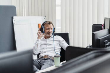 Smiling male professional with headset working in office - DIGF16041
