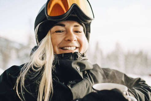 Porträt einer lächelnden blonden Frau mit Skibrille und Helm - MASF24315