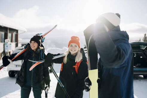 Lächelnde Freunde in einem Skigebiet im Winter - MASF24341