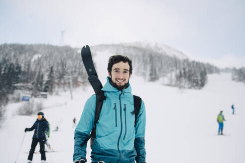 Porträt eines lächelnden Mannes in einem Skigebiet im Winter - MASF24371