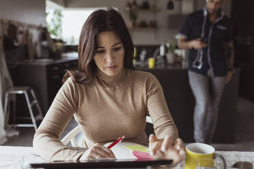 Geschäftsfrau bei der Arbeit an einem digitalen Tablet im Heimbüro - MASF24403