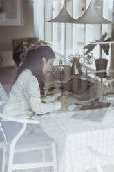 Geschäftsfrau schreibt in Tagebuch bei der Arbeit zu Hause aus dem Fenster gesehen - MASF24443