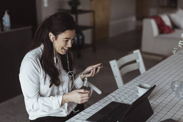 Smiling female entrepreneur on video call through laptop at home - MASF24454