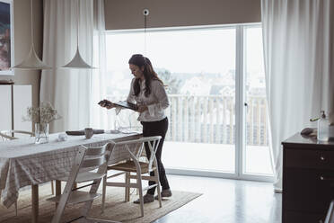 Geschäftsfrau mit digitalem Tablet im Stehen zu Hause - MASF24457