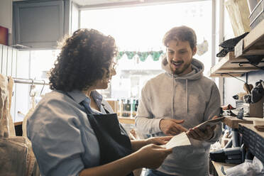 Saleswoman assisting male customer at organic shop - MASF24522