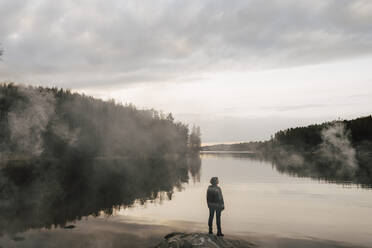 Rear view of female explorer admiring lake during sunset - MASF24554