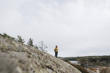 Mature female explorer standing on mountain against sky - MASF24588