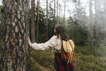 Rear view of female explorer walking in forest - MASF24614