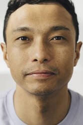 Portrait of man with hair stubble against white wall - MASF24660