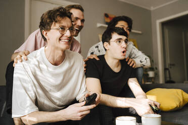 Glückliche männliche Freunde spielen ein Videospiel zu Hause - MASF24969