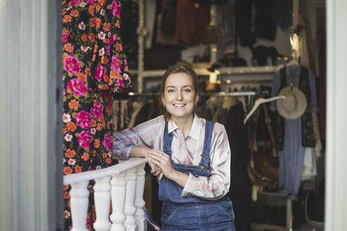 Porträt einer lächelnden Mitarbeiterin in einem Bekleidungsgeschäft - MASF25019