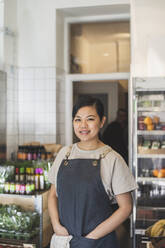 Portrait of smiling female owner with hands in pockets at store - MASF25040