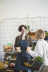 Smiling male owner talking with female customer in store - MASF25071