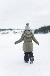 Rückansicht eines Mädchens in voller Länge auf Schnee - MASF25119