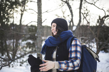 Fröhliche Frau mit Handschuhen im Winter - MASF25131