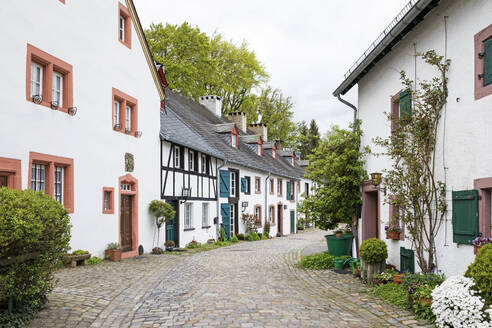 Germany, North Rhine-Westphalia, Kronenburg, Row of rustic houses along cobblestone street in historic medieval village - GWF07068