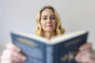 Mature woman reading book at home - WPEF04983