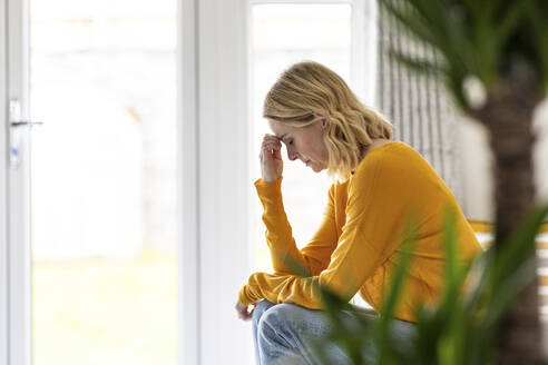 Depressive reife Frau sitzt zu Hause - WPEF04988