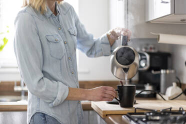 Frau bei der Zubereitung von Tee in der Küche zu Hause - WPEF05000