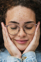 Beautiful young woman wearing eyeglasses with eyes closed - JCMF02071