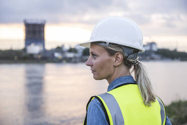 Female professional looking away at sunset - UUF23769