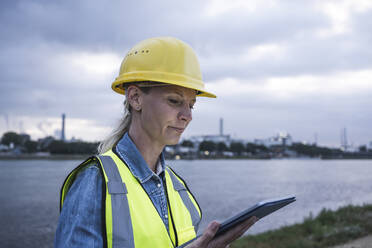 Female professional looking at digital tablet during sunset - UUF23780