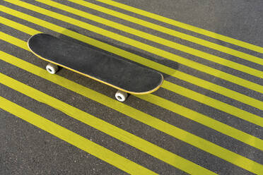 Skateboard on striped yellow road marking - VPIF04252