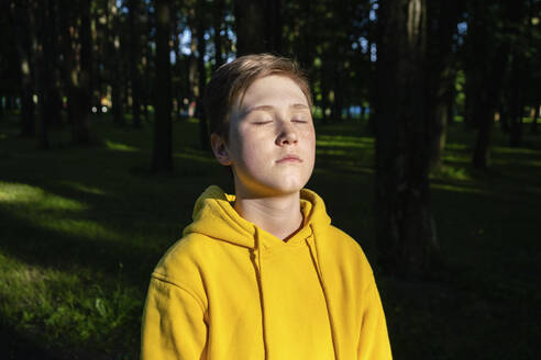 Boy with eyes closed under sunlight - VPIF04267