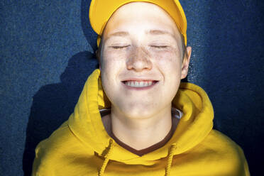 Junge in gelbem Sweatshirt lächelt mit geschlossenen Augen - VPIF04276