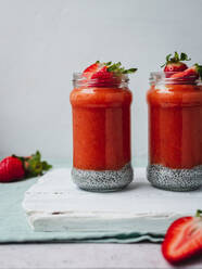 Closeup of a delicious strawberry smoothie with a yellow flower garnish - ADSF25234