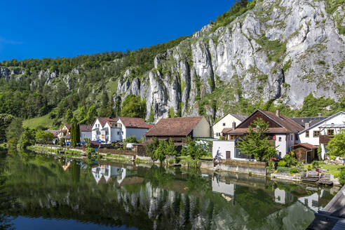 Deutschland, Bayern, Essing, Stadt am Ufer der Altmuhl mit steilem Felsen im Hintergrund - MABF00580