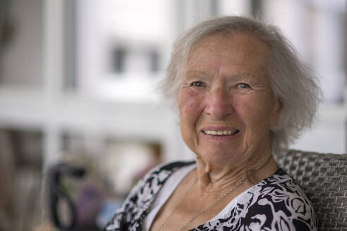 Smiling senior woman sitting on chair - WGF01385