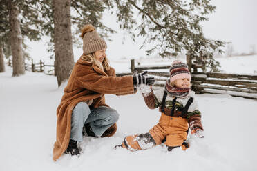 Kanada, Ontario, Mutter und Tochter (2-3) spielen im Schnee - ISF24621