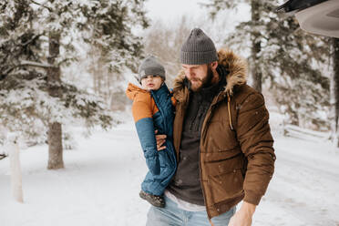 Canada, Ontario, Father holding baby boy (12-17 months) on winter day - ISF24623