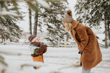 Kanada, Ontario, Mutter und Tochter (2-3) spielen mit Schnee - ISF24624