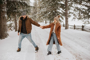 Kanada, Ontario, Lächelndes Paar hält sich bei einem Winterspaziergang an den Händen - ISF24628