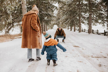 Kanada, Ontario, Eltern mit kleinem Jungen (12-17 Monate) machen einen Winterspaziergang - ISF24630