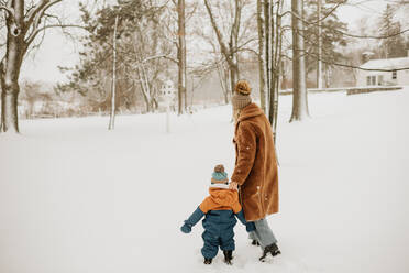 Kanada, Ontario, Mutter und kleiner Junge (12-17 Monate) auf Winterspaziergang - ISF24632