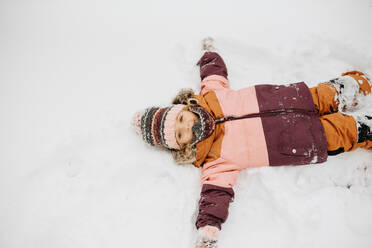 Kanada, Ontario, Mädchen (2-3) macht Schneeengel - ISF24643