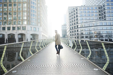 UK, London, Man walking on footbridge - ISF24655