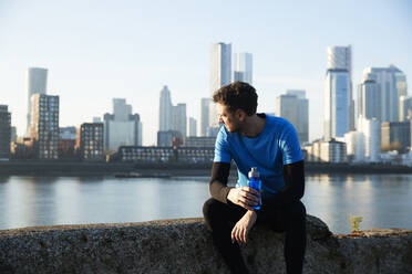 UK, London, Jogger looking at downtown skyline in background - ISF24680