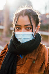 Italien, Porträt einer jungen Frau mit Gesichtsmaske im Freien - ISF24704