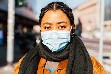 Italy, Portrait of young woman in face mask standing on city street - ISF24705