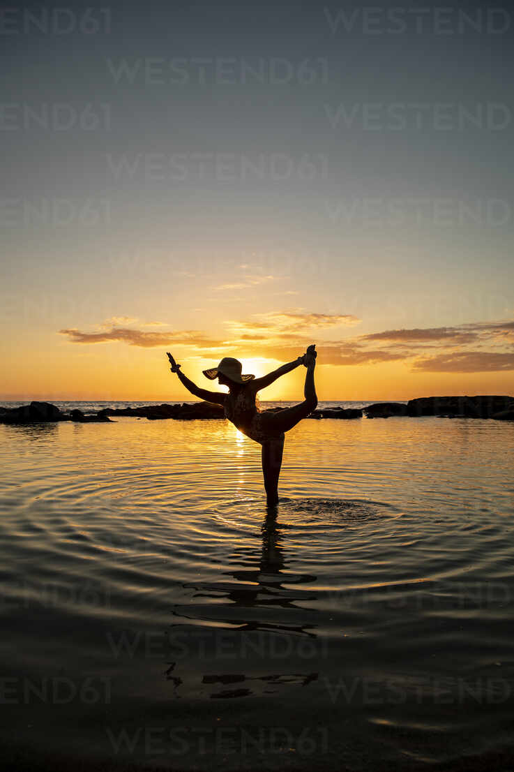 3d Female Contorting Into A Yoga Pose Against A Serene Sunset Backdrop  Powerpoint Background For Free Download - Slidesdocs