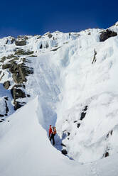 Eiskletterer beim Angehen einer Eiskletterei in den White Mountains, NH - CAVF94431