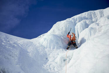 Male Ice climbing guide leading an ice climb in New Hampshire - CAVF94432