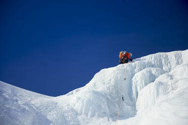 Male Ice climbing guide leading an ice climb in New Hampshire - CAVF94433