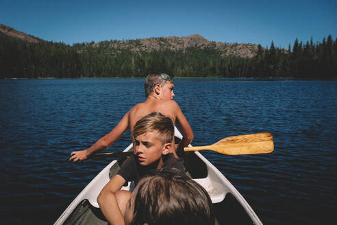 Drei Jungen begeben sich in einem kleinen Kanu auf eine Reise - CAVF94451
