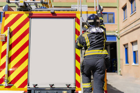 Feuerwehrmann, der in den Lkw steigt, um im Notfall zu arbeiten - CAVF94508