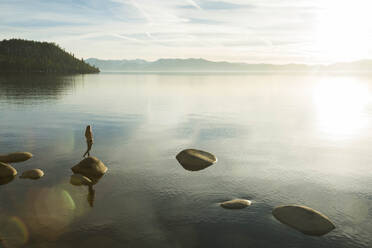 Weiblich, stehend auf einem Felsen im Lake Tahoe - CAVF94580